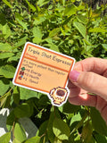 Stardew Valley Triple Shot Espresso pixel art item card die-cut sticker with espresso cup icon, held in hand outdoors against green leaves