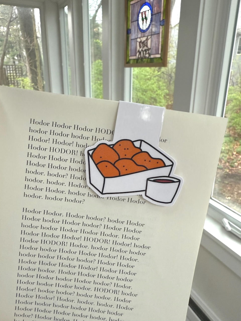 Chicken Nuggets Magnetic Bookmark clipped onto a book page, close up of nugget box and dipping sauce illustration