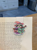 Halloween witch sloth magnetic bookmark clipped to a book page