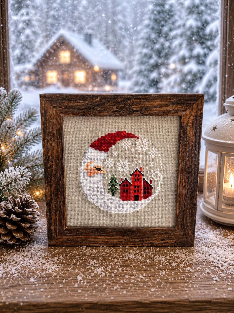 Framed cross-stitch, Santa Christmas Village, rustic wooden frame on wooden surface