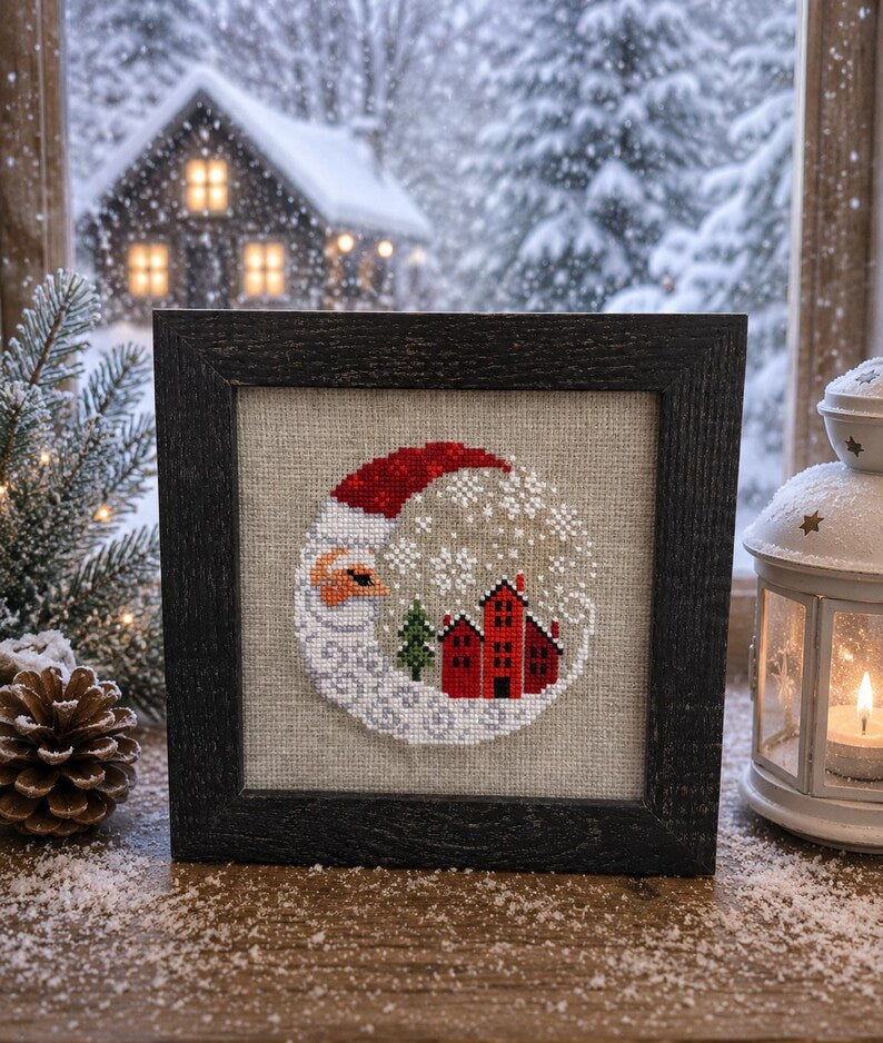 Framed cross-stitch, Santa Christmas Village, dark brown frame close-up