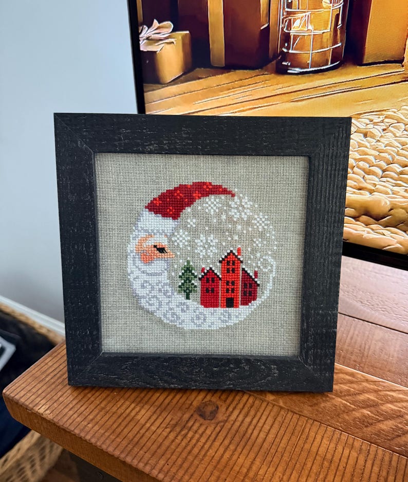 Framed cross-stitch, Santa Christmas Village, distressed black frame